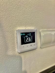 une horloge sur un mur avec une maison dessus dans l'établissement Bálint Apartman 1, à Valea Strîmbă