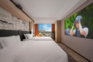 a hotel room with two beds and a flat screen tv at Arthur Hotel Baiyun Station Xinshixu Subway Station Guangzhou in Guangzhou