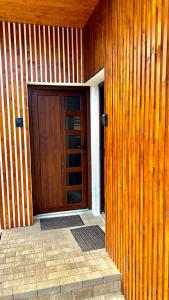 une porte en bois sur le côté d'un bâtiment dans l'établissement Bálint Apartman 1, à Valea Strîmbă