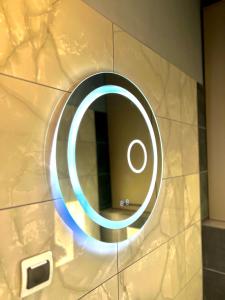 un miroir rond sur un mur dans une salle de bain dans l'établissement Bálint Apartman 1, à Valea Strîmbă