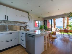 a kitchen with white cabinets and a counter with a table at Blue Horizon Retreat in Playa del Aguila