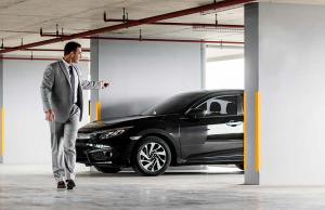 Ein Mann im Anzug steht neben einem schwarzen Auto. in der Unterkunft Centro & Mare - Rooms - Suites - Garage in Termoli