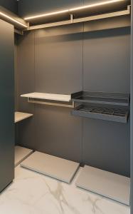 Magnum Nampo Hotel في Jung-gu: خزانة ملابس بجدران رمادية ورفوف