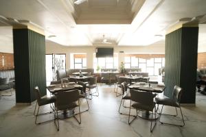 Hotel Kartiki في أورانغاباد: غرفة طعام بها طاولات وكراسي وتلفزيون