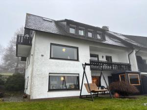 ein weißes Haus mit Lichtern in den Fenstern in der Unterkunft Haus Aktiv Top2 in Winterberg