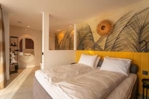 a large bed in a room with a painting on the wall at ORANGE LOUNGE Attersee in Weyregg