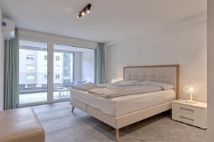 una camera da letto con un letto e una grande finestra di Apartment JungfrauCenter Brienzersee - GRIWA RENT a Interlaken