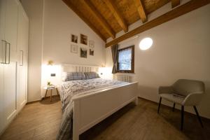 a bedroom with a bed and a chair and a window at Casa Closellinaz in Roisan