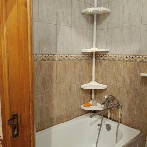 a bathroom with a bath tub with three lights above it at Квартира in Sumy