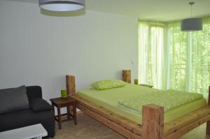 a bedroom with a wooden bed and a couch at Punkrock Harbour Pension Bähr in Karlsruhe