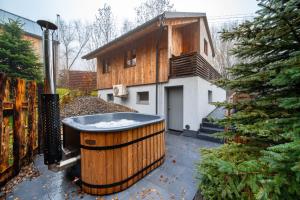 a large wooden tub in front of a house at LES-wellness in Pastviny