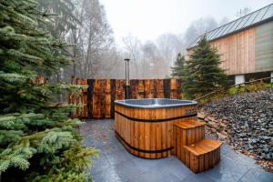 a hot tub in a yard next to a wooden fence at LES-wellness in Pastviny