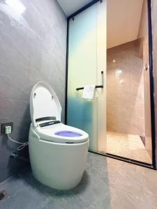 e bagno con doccia e servizi igienici bianchi. di Lijiang Hengchang Baoyin Mohuakai Inn a Lijiang