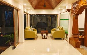un salon avec deux chaises jaunes et une table dans l'établissement Great Escapes Resorts, à Chinnakanal