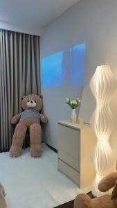 a brown teddy bear sitting in a room with a tv at Gia An Homestay in Phú Thú