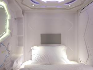 Una habitación blanca con una cama y un televisor. en Capsule Hotel Happy lounge, en Tiflis