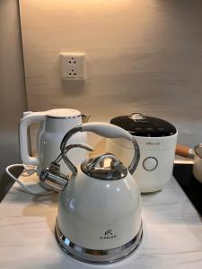 a white tea kettle on a counter next to a toaster at Gia An Homestay in Phú Thú