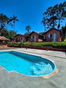 a swimming pool in front of a house at Recanto Raios do Sol in Caldas