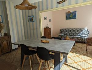 a living room with a table with chairs and a couch at Villa 100m plage in La Faute-sur-Mer