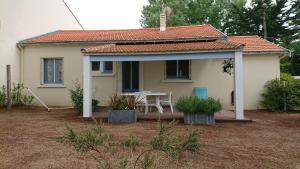 a small white house with a table and chairs at Villa 100m plage in La Faute-sur-Mer