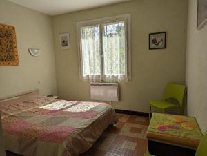 a bedroom with a bed and a window and a chair at Villa 100m plage in La Faute-sur-Mer