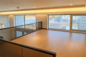 ein leerer Raum mit Holzboden und großen Fenstern in der Unterkunft Magnum Nampo Hotel in Busan