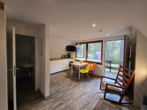 una cucina e una sala da pranzo con tavolo e sedie di Glücklich am Strand - Ruhe im Kiefernwald mit Terrasse & Hund willkommen a Trassenheide