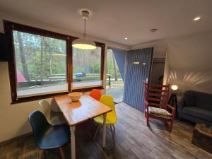 a living room with a table and chairs at Glücklich am Strand - Ruhe im Kiefernwald mit Terrasse & Hund willkommen - Heinrich in Trassenheide