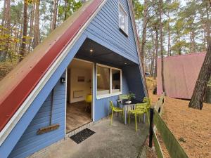 una casetta blu minuscola con tavolo e sedie di Glücklich am Strand - Ruhe im Kiefernwald mit Terrasse & Hund willkommen a Trassenheide