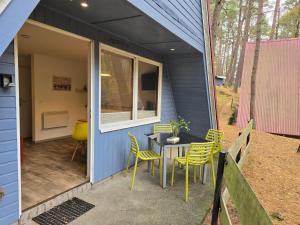 una casetta minuscola con un tavolo e sedie sul portico di Glücklich am Strand - Ruhe im Kiefernwald mit Terrasse & Hund willkommen a Trassenheide
