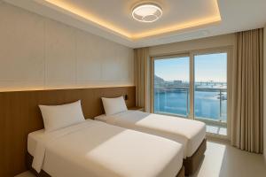 Magnum Nampo Hotel في Jung-gu: سريرين في غرفة ذات نافذة كبيرة +16 صورة