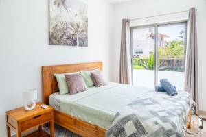 a bedroom with a large bed and a window at Azure 4 Bedrooms Haven Retreat: Where Tranquility Meets Turquoise Waters, Flic en Flac Mauritius in Flic-en-Flac +33 photos