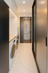 Magnum Nampo Hotel في Jung-gu: غرفة غسيل مع غسالة ومجفف