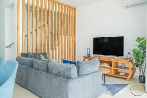 a living room with two couches and a television at Azure 4 Bedrooms Haven Retreat: Where Tranquility Meets Turquoise Waters, Flic en Flac Mauritius in Flic-en-Flac