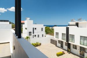 a view from the balcony of a white building at Azure 4 Bedrooms Haven Retreat: Where Tranquility Meets Turquoise Waters, Flic en Flac Mauritius in Flic-en-Flac