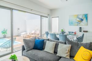 a living room with a couch and a dining room at Azure 4 Bedrooms Haven Retreat: Where Tranquility Meets Turquoise Waters, Flic en Flac Mauritius in Flic-en-Flac
