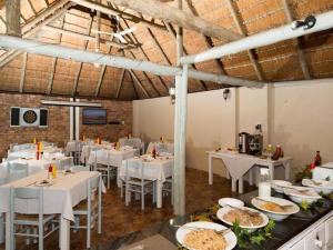 a dining room with white tables and white chairs at St. Lucia Safari Lodge in St Lucia