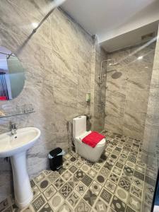 a bathroom with a toilet and a sink and a shower at Ostro Hotel in Phnom Penh