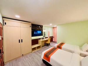 a hotel room with two beds and a desk at Baan Chanchay Hua Hin in Hua Hin