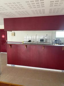 a kitchen with red walls and a counter in a room at hotel barbery in La Celle-sous-Gouzon