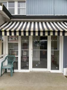 a green bench sitting in front of a store window at hotel barbery in La Celle-sous-Gouzon