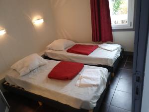 two twin beds in a room with a window at hotel barbery in La Celle-sous-Gouzon