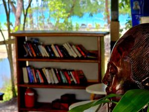 a book shelf filled with books next to a chair at White Beach Resort Longset in Koh Rong Island