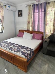 un piccolo letto in una stanza con un divano e delle tende di Kings Lounge a Ayaso