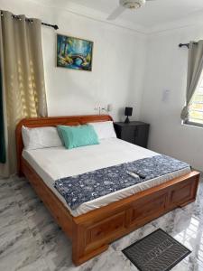 un letto con struttura in legno in una camera da letto di Kings Lounge a Ayaso