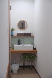 松山一棟貸し宿Tsuji في ماتسوياما: حمام مزود بحوض ومِرآة