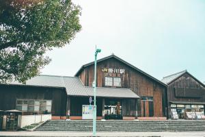 Kuretake-Inn Kakegawa في كاكِغو: مبنى خشبي كبير على بعد خطوات منه