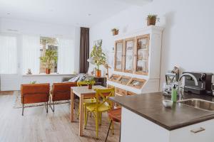a kitchen and living room with a table and chairs at Bed & Breakfast Het Vinkenest Nijverdal in Nijverdal