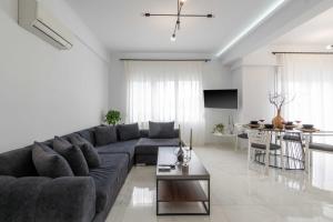 uma sala de estar com um sofá e uma mesa em Arcade Apartments 1st floor em Volos