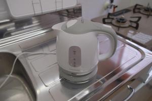 松山一棟貸し宿Tsuji في ماتسوياما: كوب أبيض موضوع فوق الثلاجة